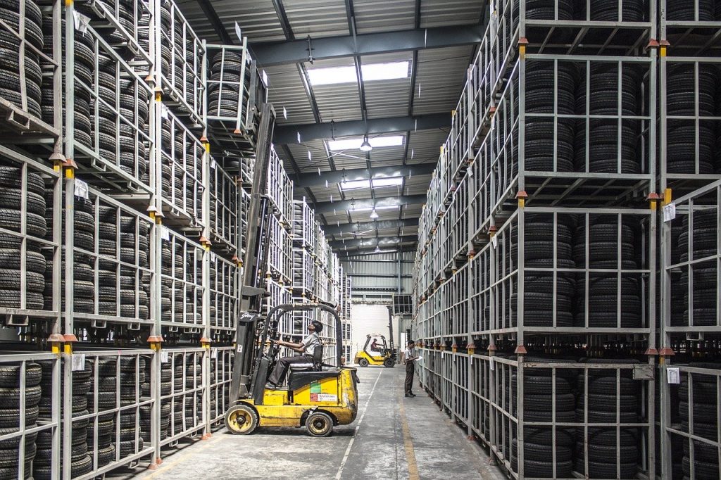 personne conduisant un chariot élévateur dans un entrepôt logistique